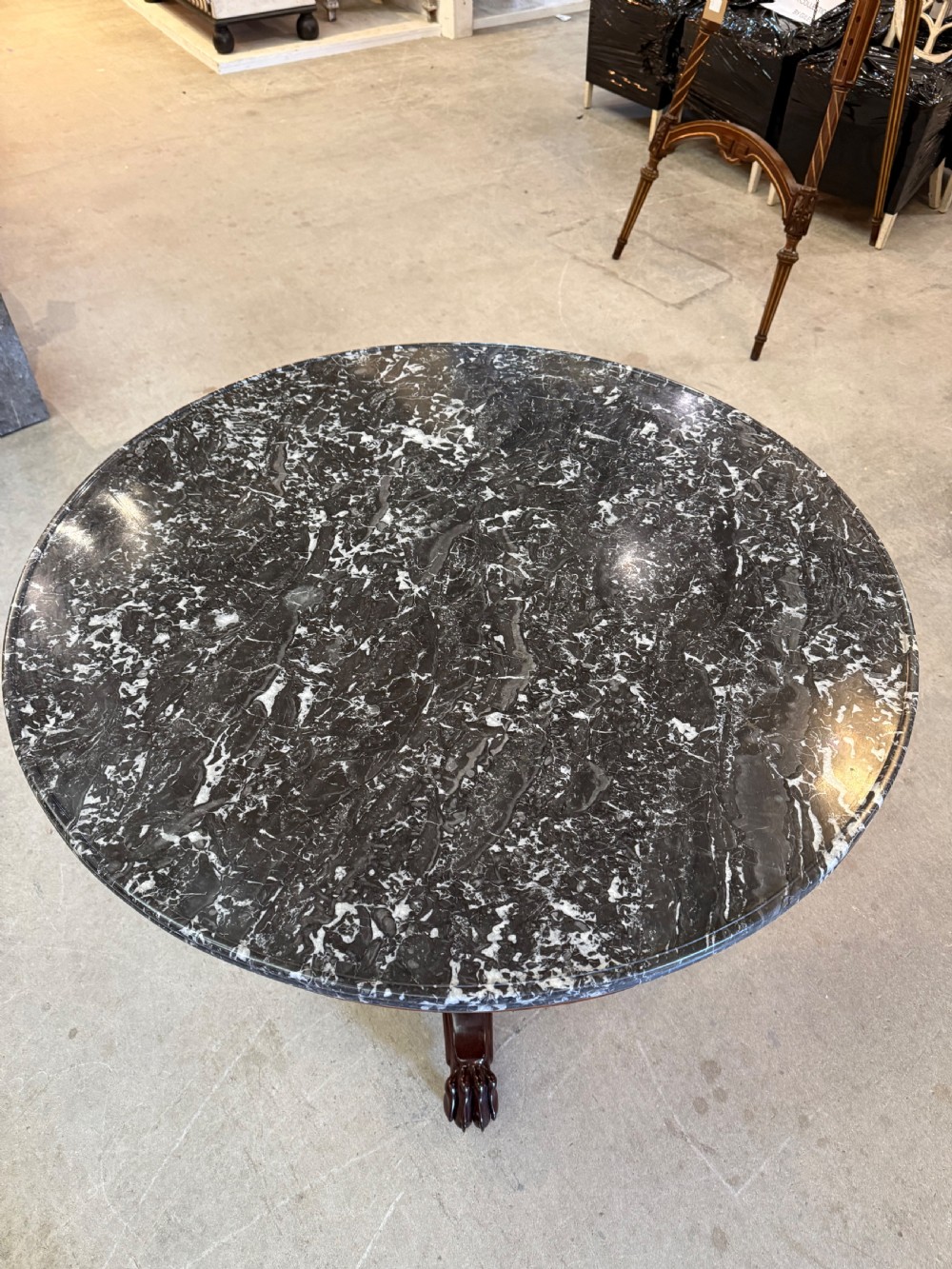 A 19th-century circular centre table featuring a dark veined marble top supported by a carved mahogany pedestal stem and a tripartite claw-foot base. View IX