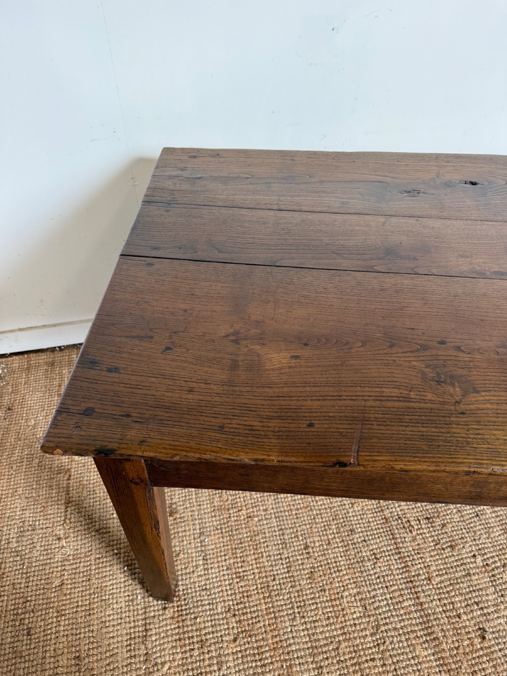 A three metre long antique oak farmhouse table featuring a three-plank top and straight tapered square legs. View V