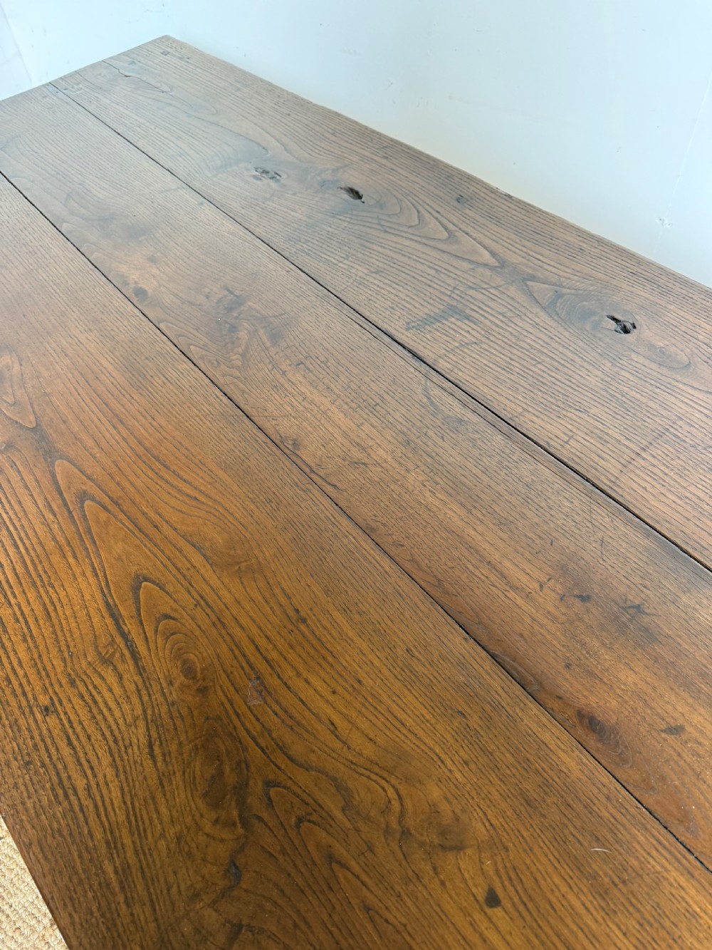 A three metre long antique oak farmhouse table featuring a three-plank top and straight tapered square legs. View VI