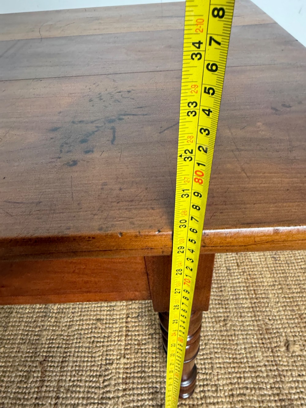 An antique rectangular cherrywood console table with a plank top, single central drawer with a turned knob, and four baluster turned legs. View XIII