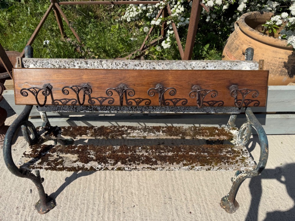 A wall-mounted dark oak coat rack featuring six scroll-shaped wrought iron hooks evenly spaced along a rectangular wooden backboard. View IV