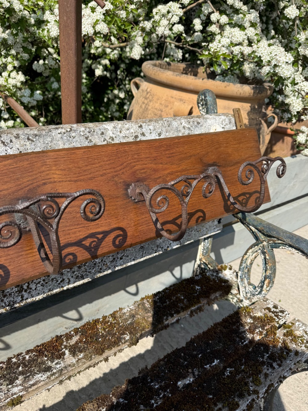 A wall-mounted dark oak coat rack featuring six scroll-shaped wrought iron hooks evenly spaced along a rectangular wooden backboard. View VII