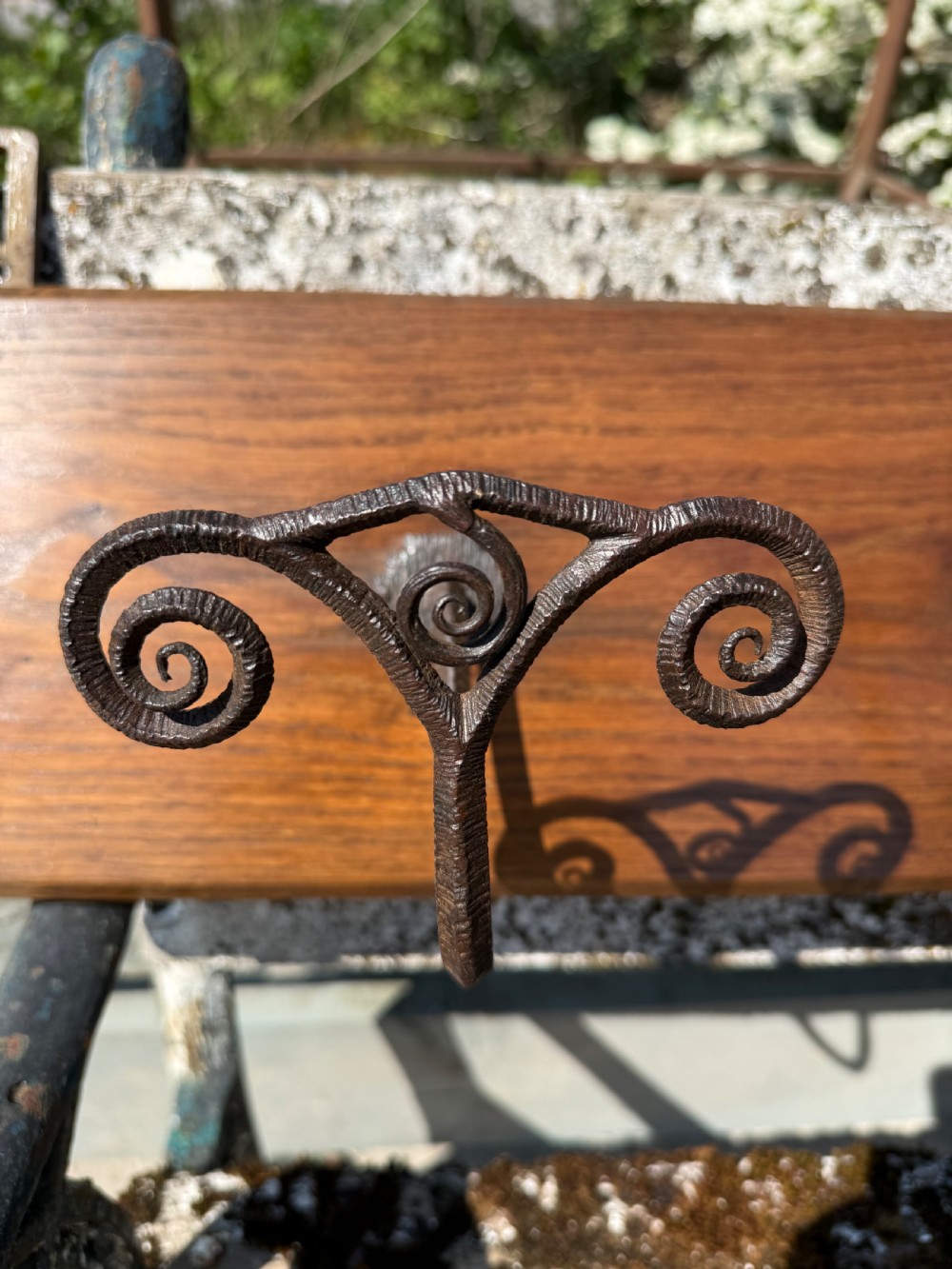 A wall-mounted dark oak coat rack featuring six scroll-shaped wrought iron hooks evenly spaced along a rectangular wooden backboard. View VIII