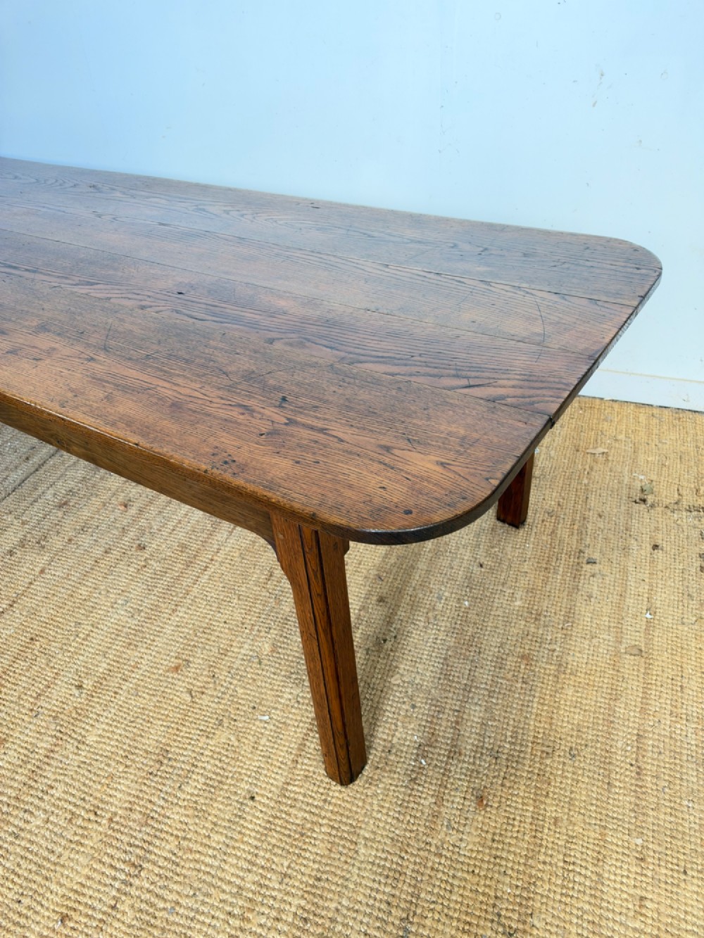 A large late nineteenth-century solid oak farmhouse dining table featuring a plank top with rounded corners and four straight legs. View II