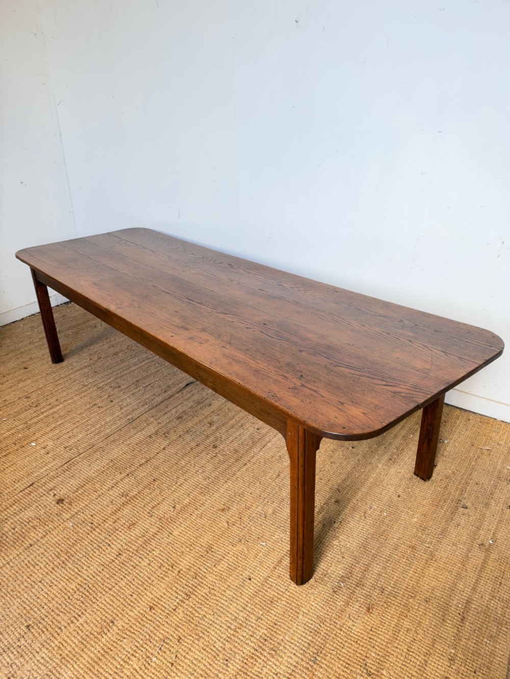 A large late nineteenth-century solid oak farmhouse dining table featuring a plank top with rounded corners and four straight legs. View III