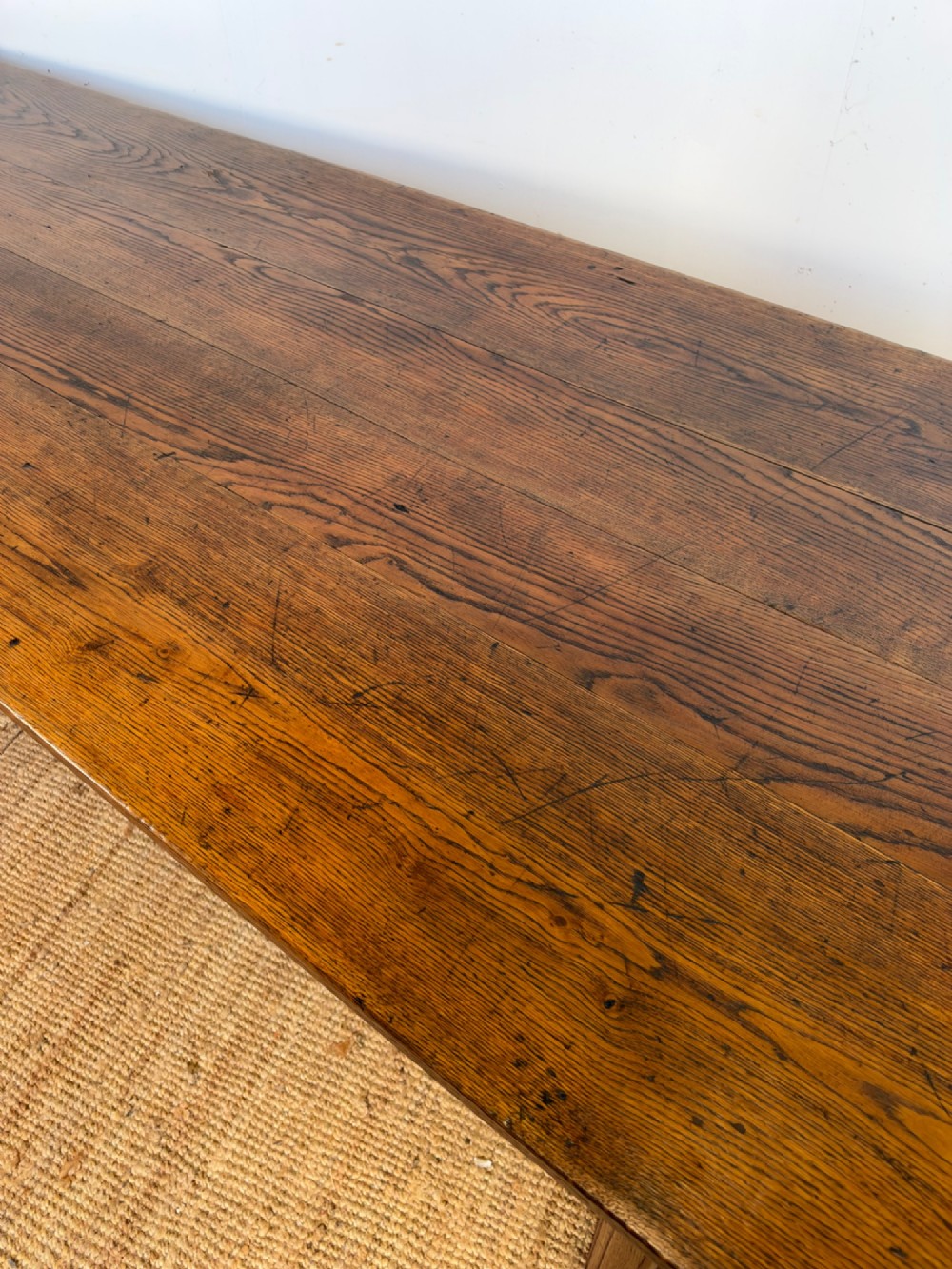 A large late nineteenth-century solid oak farmhouse dining table featuring a plank top with rounded corners and four straight legs. View V