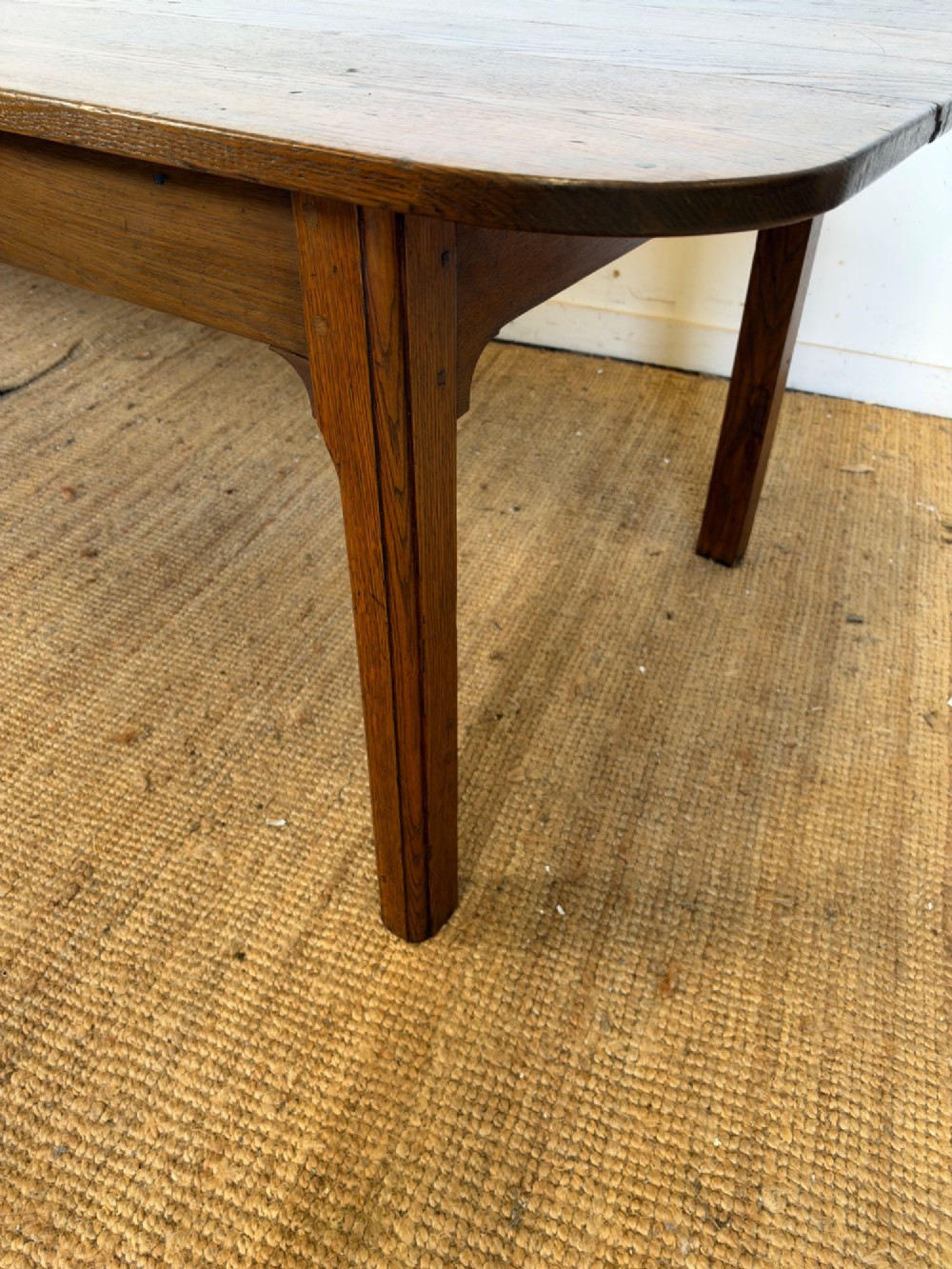 A large late nineteenth-century solid oak farmhouse dining table featuring a plank top with rounded corners and four straight legs. View VII