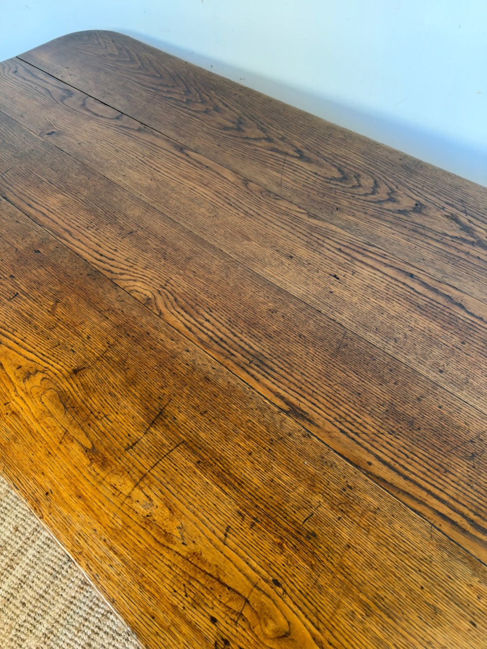 A large late nineteenth-century solid oak farmhouse dining table featuring a plank top with rounded corners and four straight legs. View XI