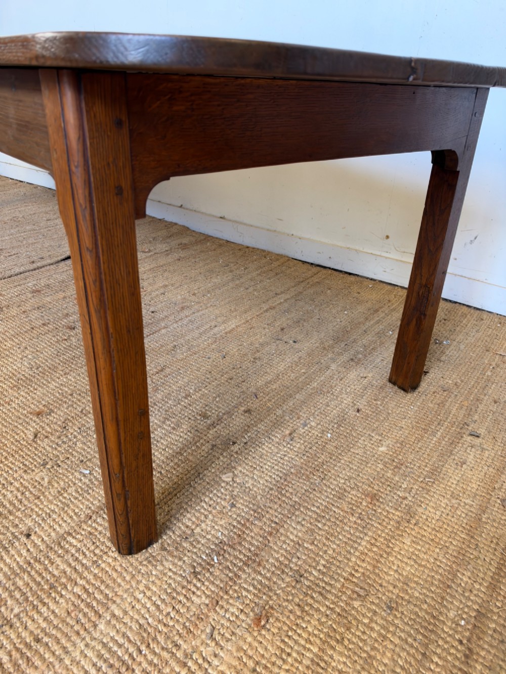A large late nineteenth-century solid oak farmhouse dining table featuring a plank top with rounded corners and four straight legs. View XII