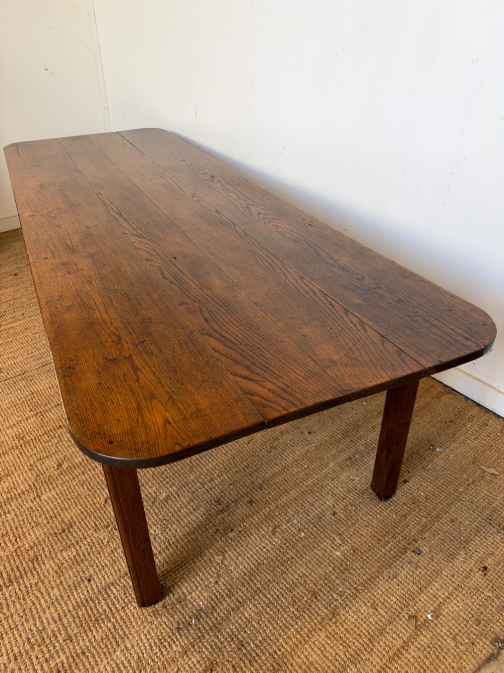 A large late nineteenth-century solid oak farmhouse dining table featuring a plank top with rounded corners and four straight legs. View XIV