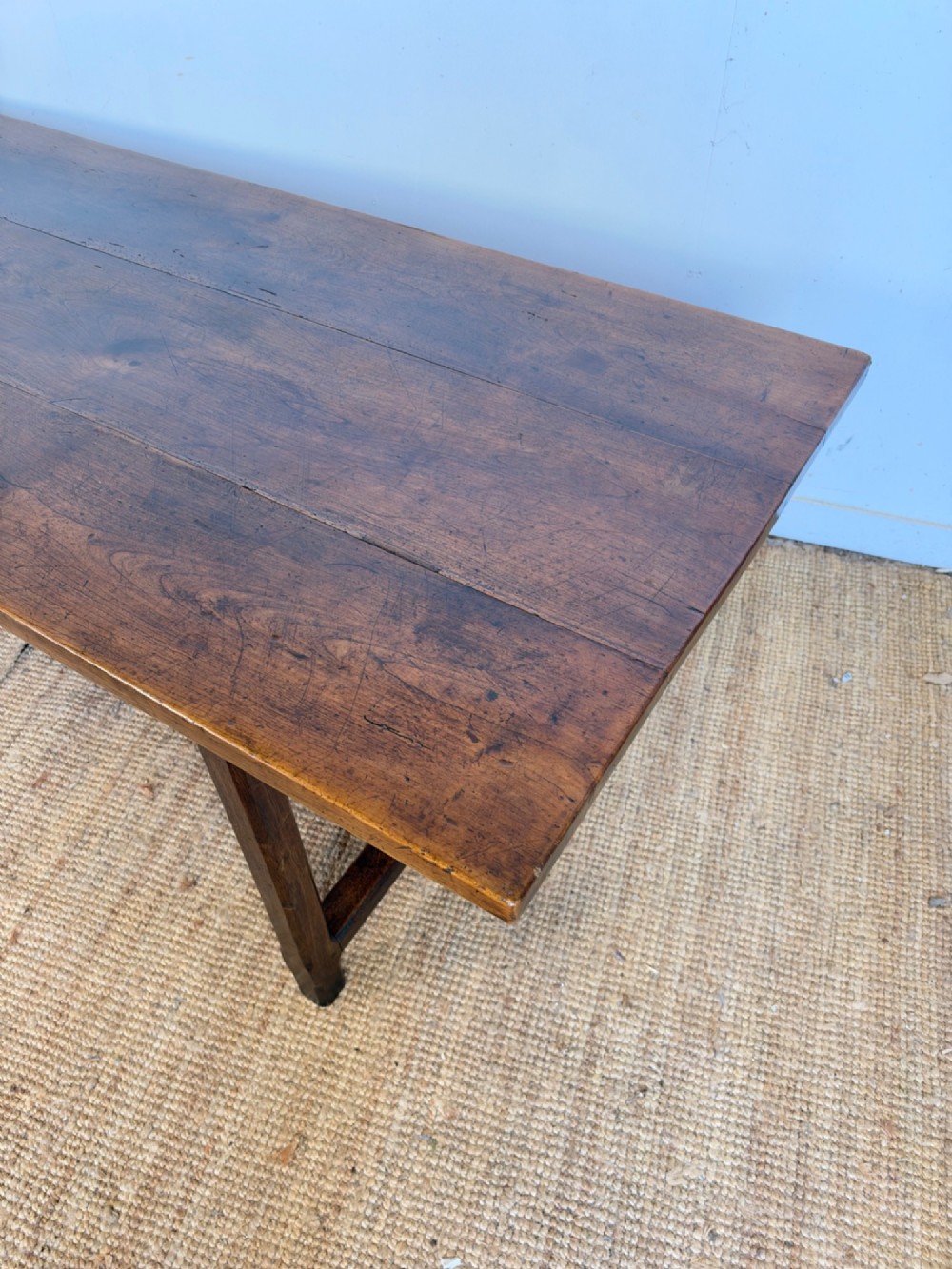 A rustic rectangular cherrywood farmhouse dining table with a three-plank top and an H-stretcher base. View II