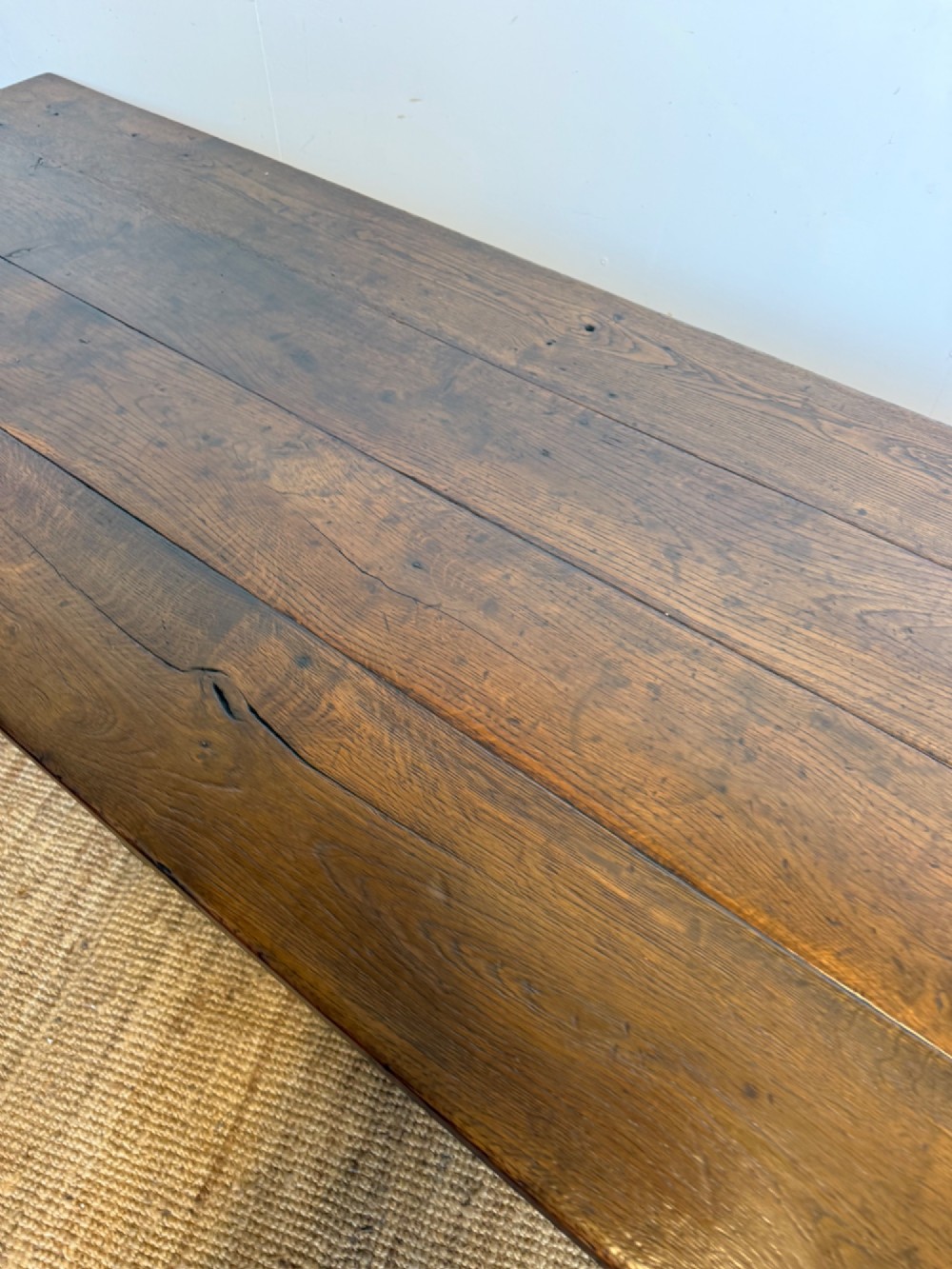 A long dark oak French farmhouse dining table with a plank top and an H-stretcher base structure. View VI