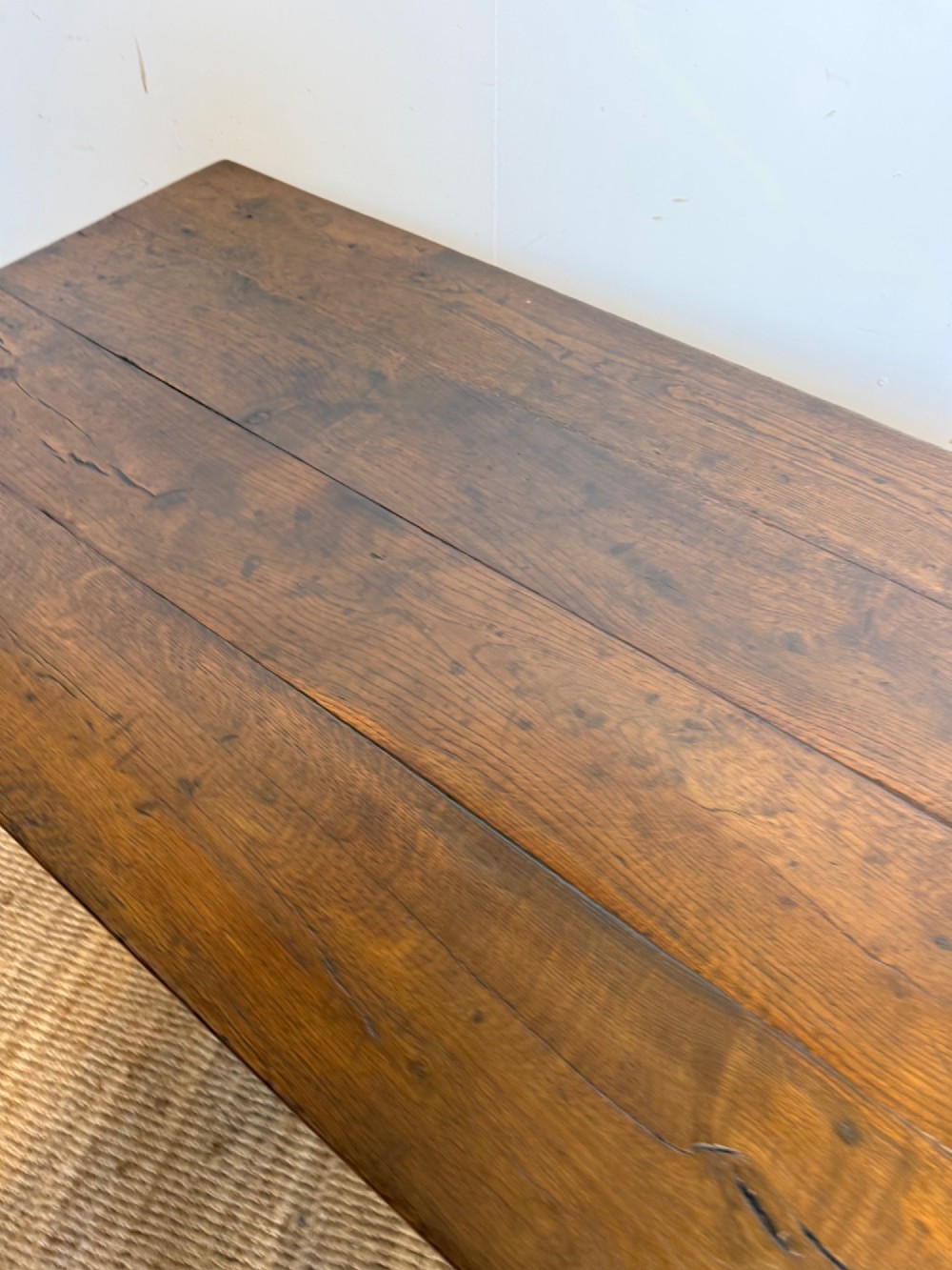 A long dark oak French farmhouse dining table with a plank top and an H-stretcher base structure. View VII