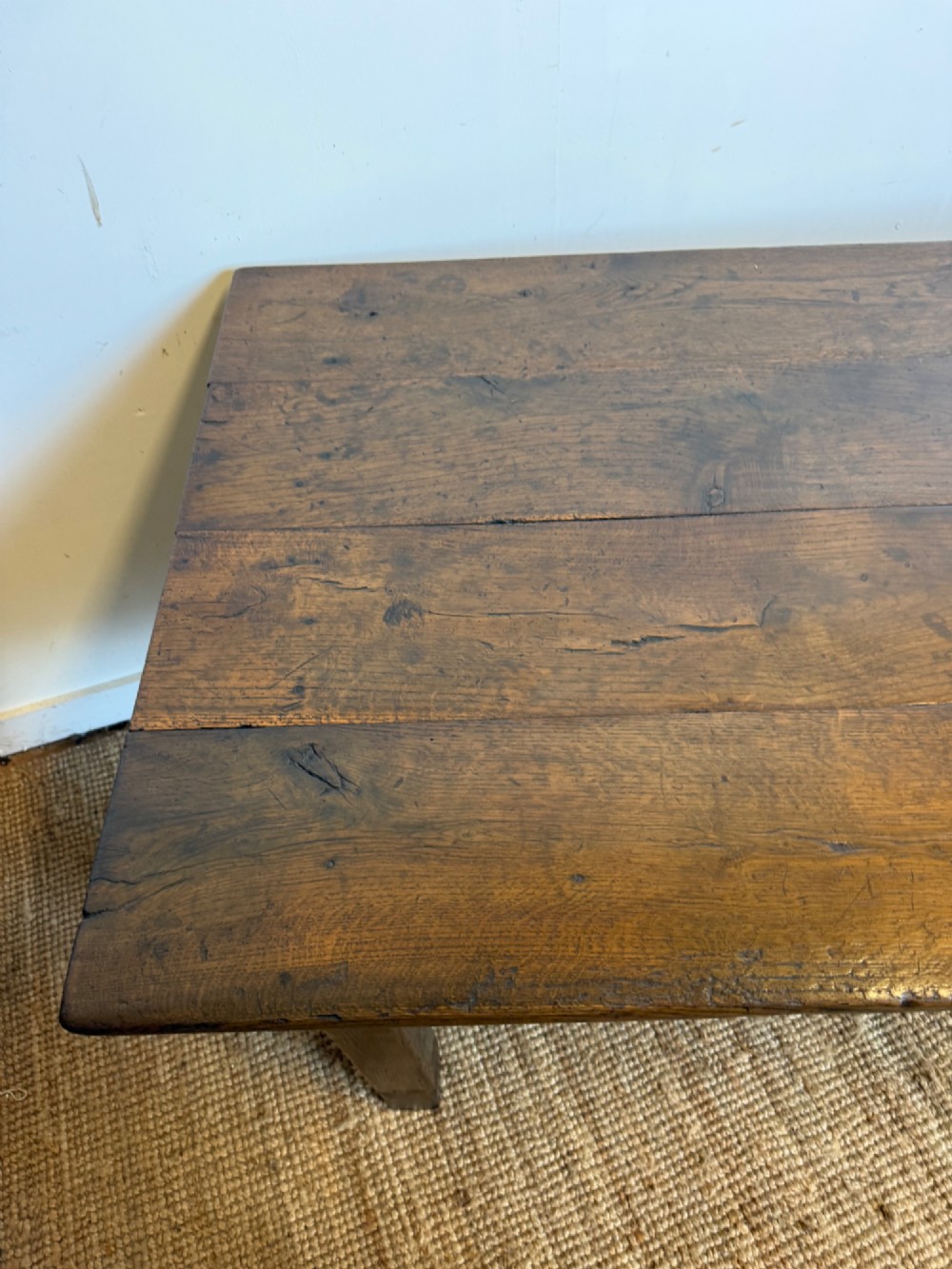 A long dark oak French farmhouse dining table with a plank top and an H-stretcher base structure. View VIII