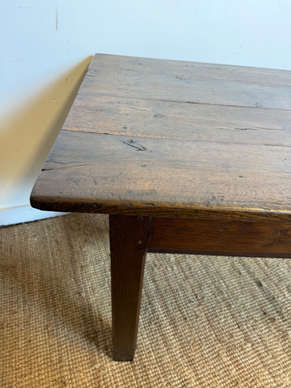 A long dark oak French farmhouse dining table with a plank top and an H-stretcher base structure. View IX