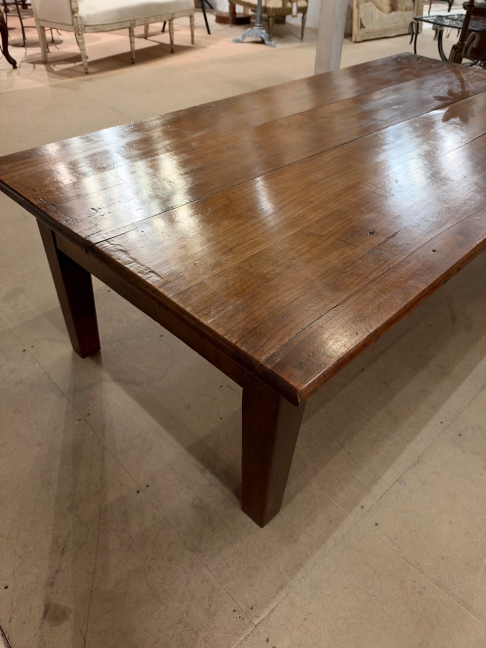 A large rectangular warm brown cherrywood coffee table featuring a plank top, tapered square legs, and a small drawer with a ring pull handle. View II