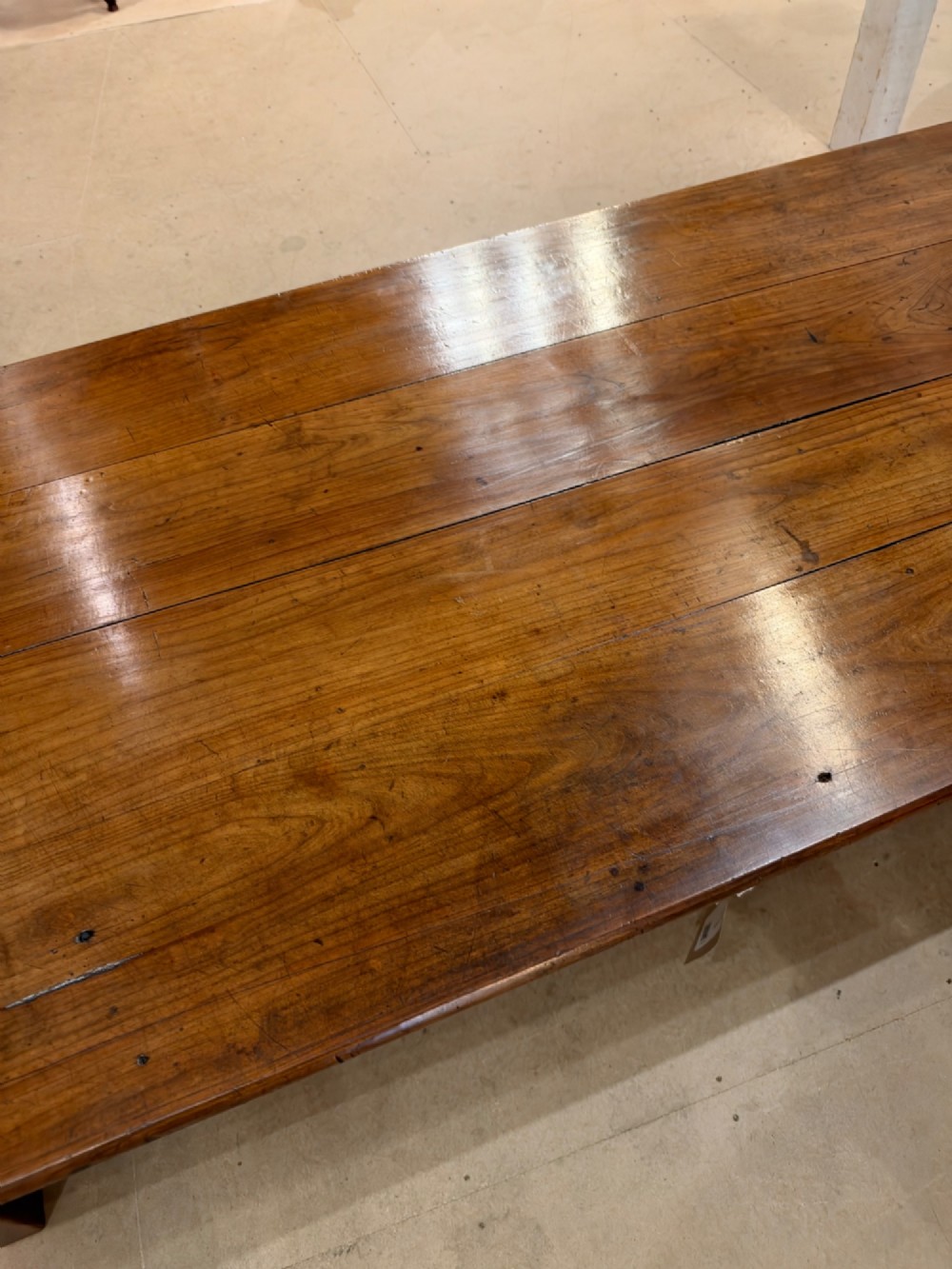 A large rectangular warm brown cherrywood coffee table featuring a plank top, tapered square legs, and a small drawer with a ring pull handle. View IV