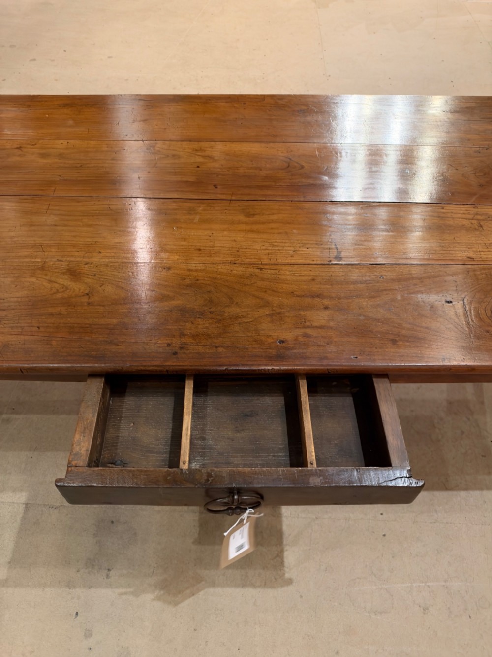 A large rectangular warm brown cherrywood coffee table featuring a plank top, tapered square legs, and a small drawer with a ring pull handle. View VI