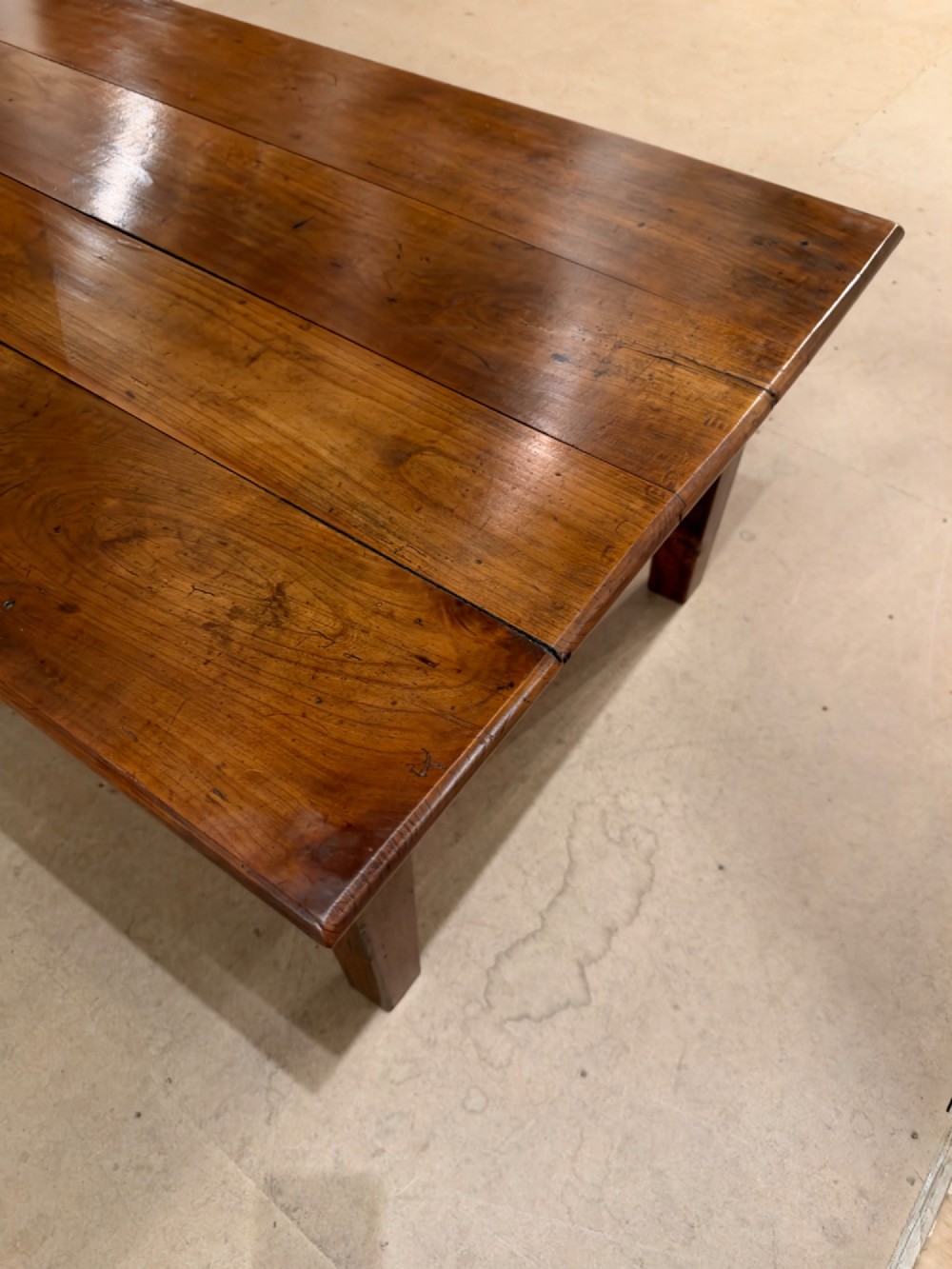 A large rectangular warm brown cherrywood coffee table featuring a plank top, tapered square legs, and a small drawer with a ring pull handle. View VIII