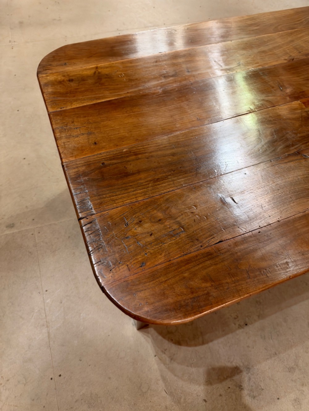A low rectangular cherrywood coffee table featuring a plank top with rounded corners, tapered square legs, and a small side drawer. View II