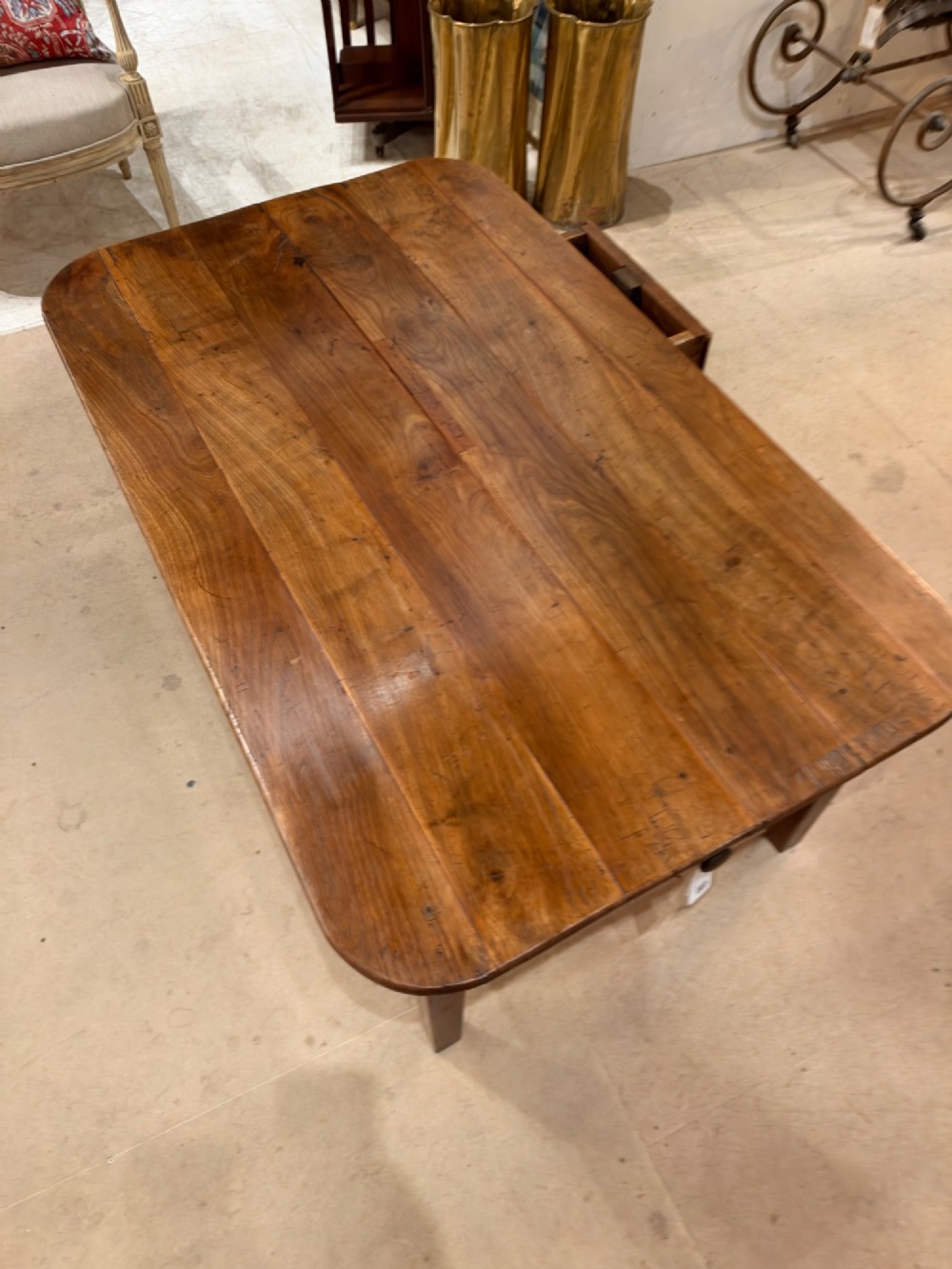 A low rectangular cherrywood coffee table featuring a plank top with rounded corners, tapered square legs, and a small side drawer. View VIII