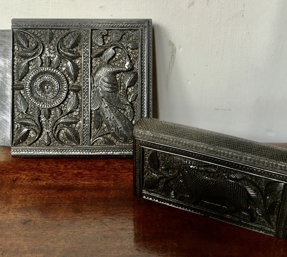 A rectangular dark carved wood card case decorated with high-relief carvings of animals, foliage, and a central circular floral motif. View IV