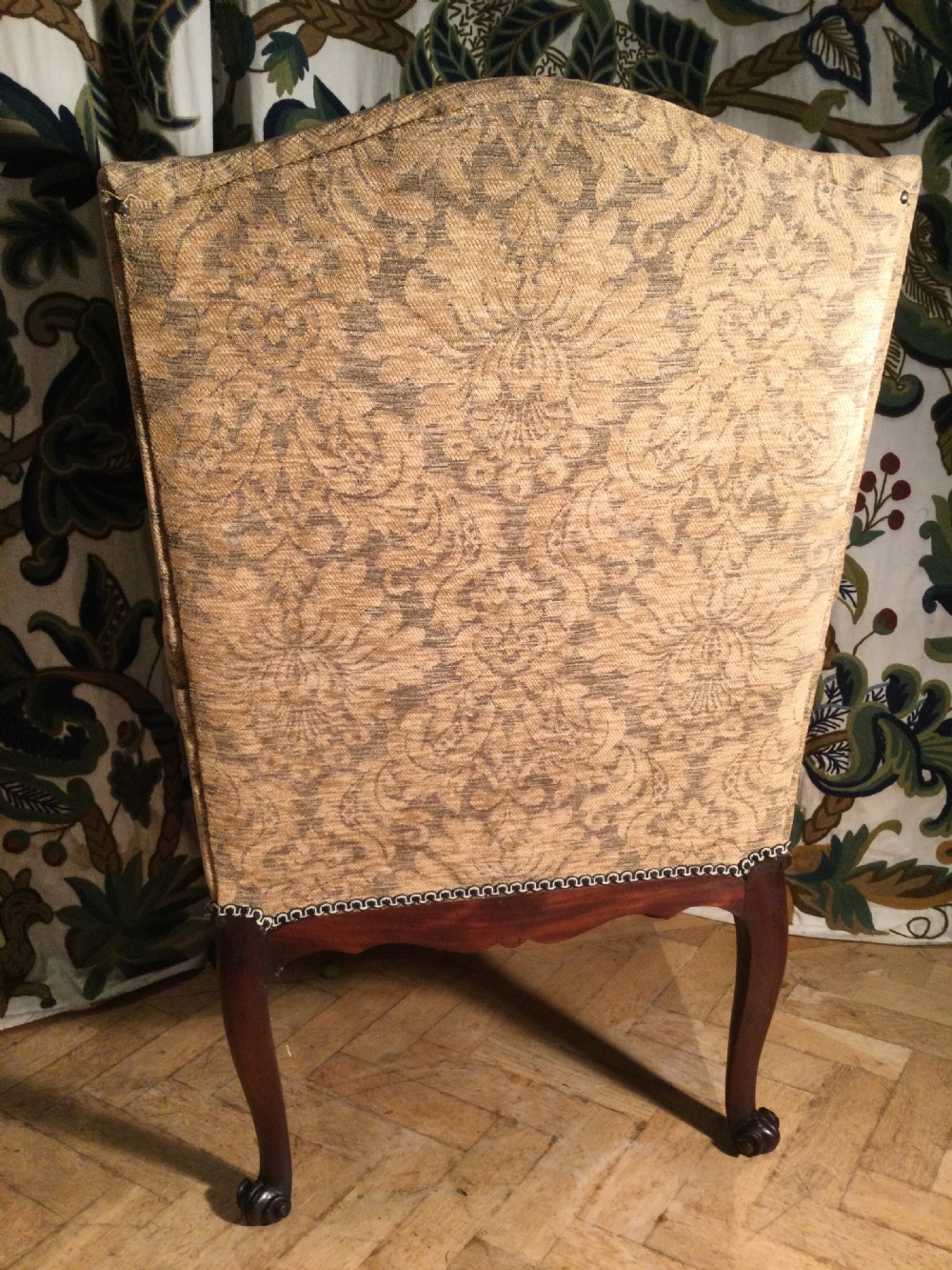 An upholstered open armchair featuring dark mahogany carved cabriole legs and patterned beige fabric upholstery. View VII