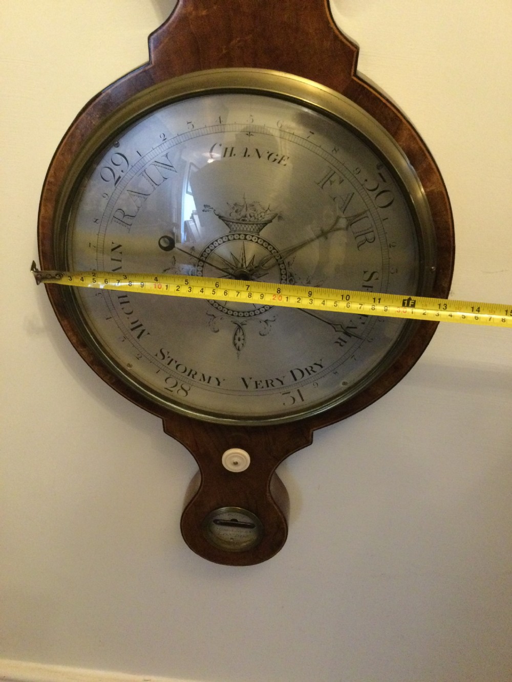 A wall-mounted Georgian mahogany banjo barometer featuring a swan-neck pediment, brass finial, hygrometer dial, central spirit thermometer, and lower dial. View III