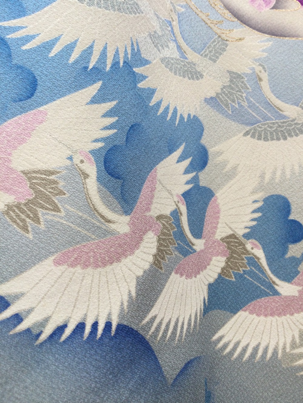 A full-length Japanese silk kimono in light blue decorated with flying purple and white cranes among stylized cloud motifs. View IV