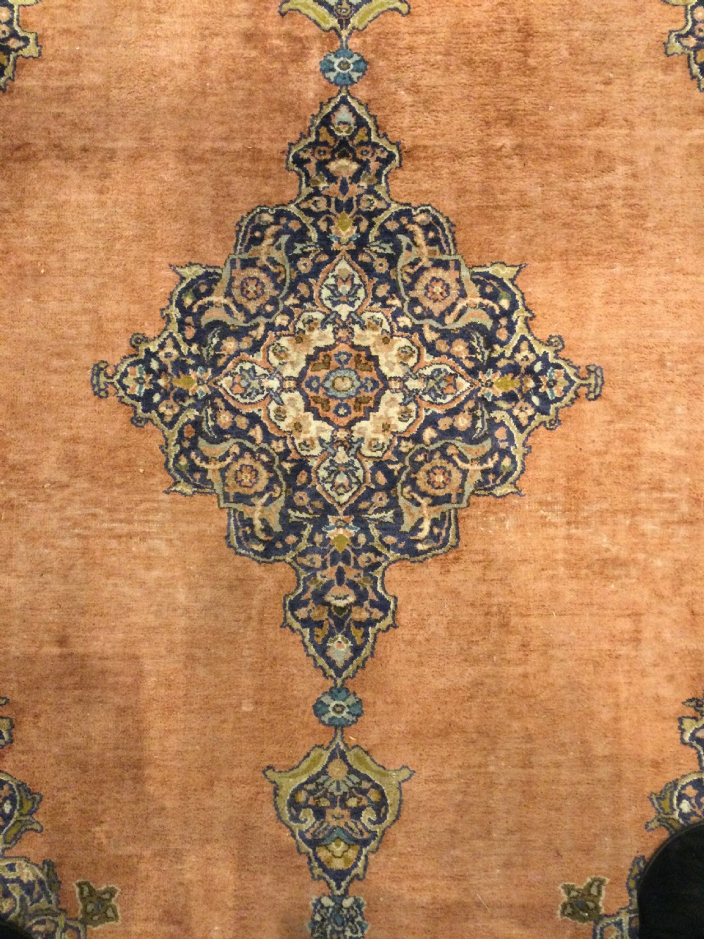A rectangular hand-knotted wool rug featuring a central navy and cream medallion on a terracotta field with patterned spandrels and a multi-banded border. View II