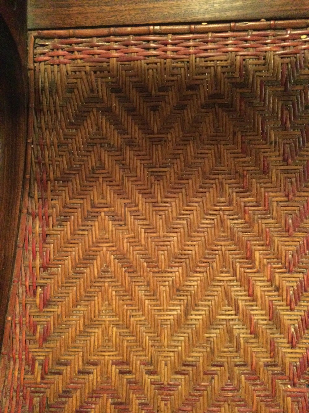 A pair of dark hardwood Chinese export armchairs featuring rope-twist top rails, inlaid horizontal splats, curved arms, and chevron-patterned woven cane seats. View IV