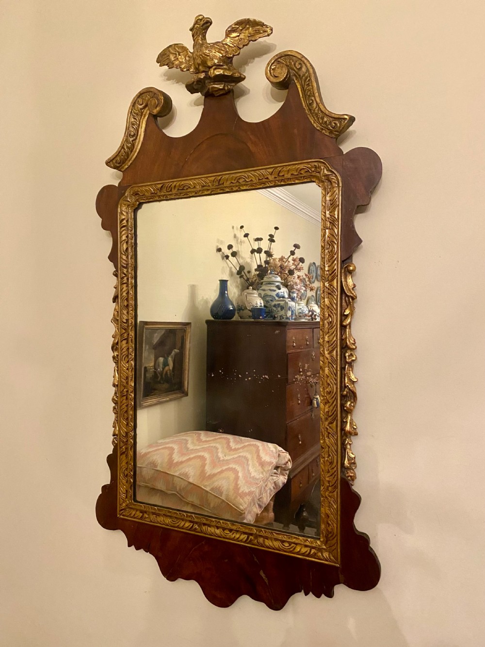 A Georgian Chippendale style mahogany wall mirror featuring a fret-cut frame topped with a carved gilded eagle finial and an inner gilded moulding. View II