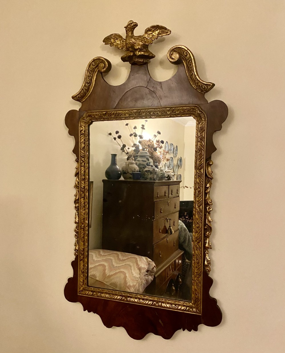 A Georgian Chippendale style mahogany wall mirror featuring a fret-cut frame topped with a carved gilded eagle finial and an inner gilded moulding. View IV