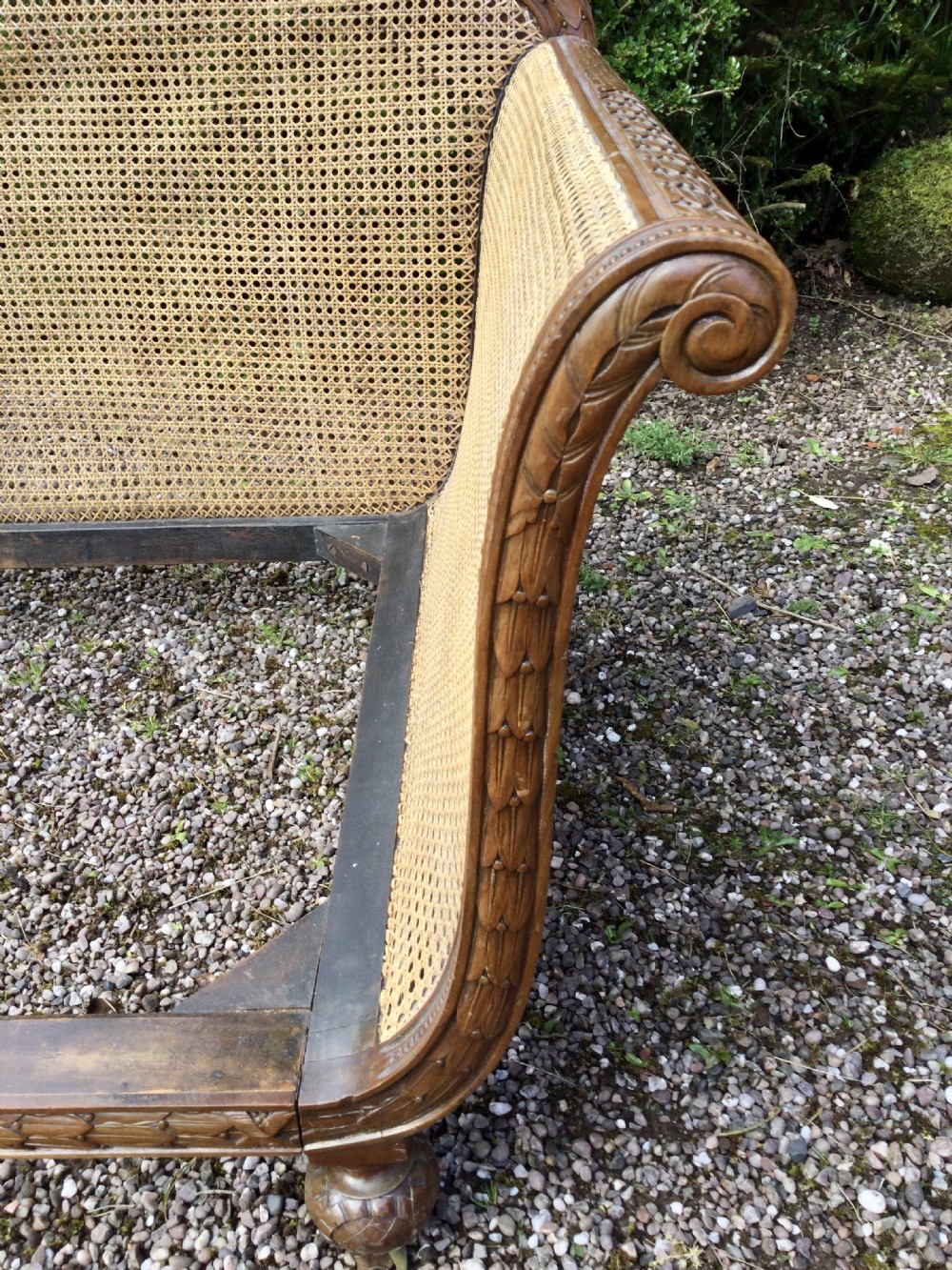 A French caned bergere sofa with a carved walnut frame, double-walled woven cane back, and a fabric seat cushion. View VII