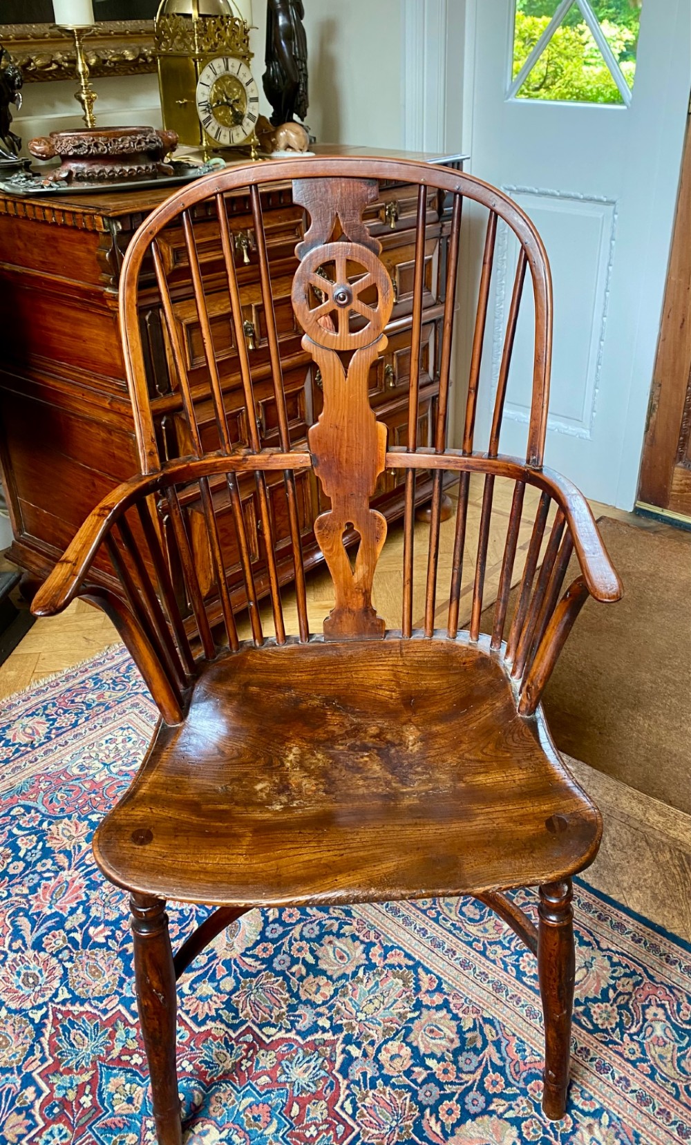An antique yew wood Windsor armchair featuring a hoop back with a decorative wheelback splat, shaped saddle seat, and turned legs. View II