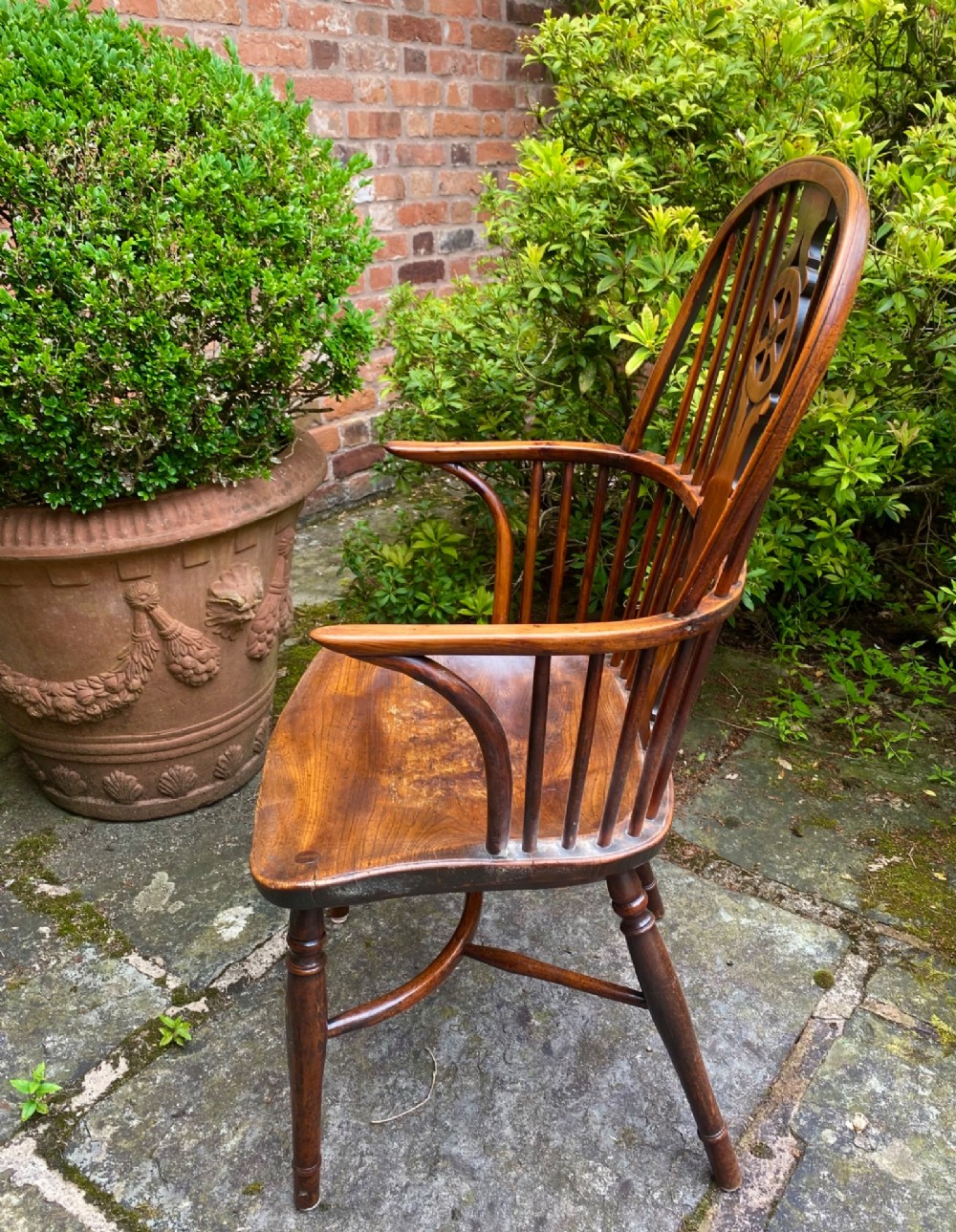An antique yew wood Windsor armchair featuring a hoop back with a decorative wheelback splat, shaped saddle seat, and turned legs. View IV
