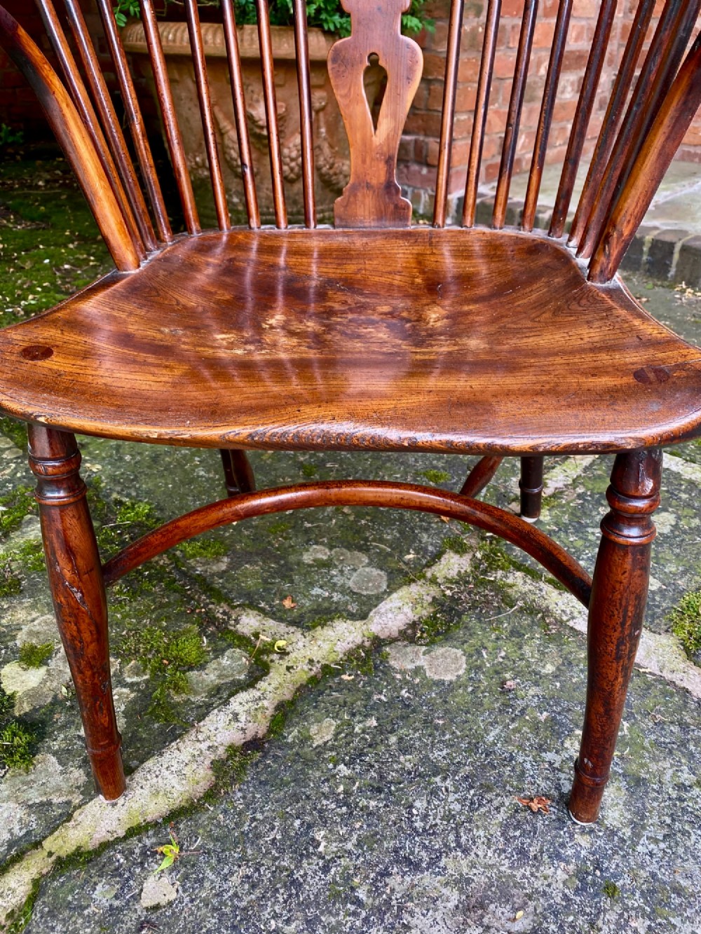 An antique yew wood Windsor armchair featuring a hoop back with a decorative wheelback splat, shaped saddle seat, and turned legs. View V