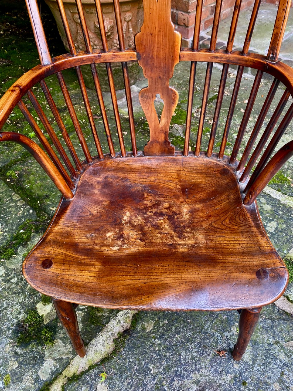 An antique yew wood Windsor armchair featuring a hoop back with a decorative wheelback splat, shaped saddle seat, and turned legs. View VI
