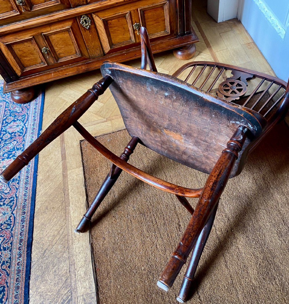 An antique yew wood Windsor armchair featuring a hoop back with a decorative wheelback splat, shaped saddle seat, and turned legs. View VIII