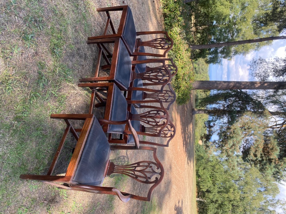 A set of mahogany dining chairs featuring carved openwork back splats, shaped armrests on the carver chairs, and dark fabric upholstered seat pads. View II