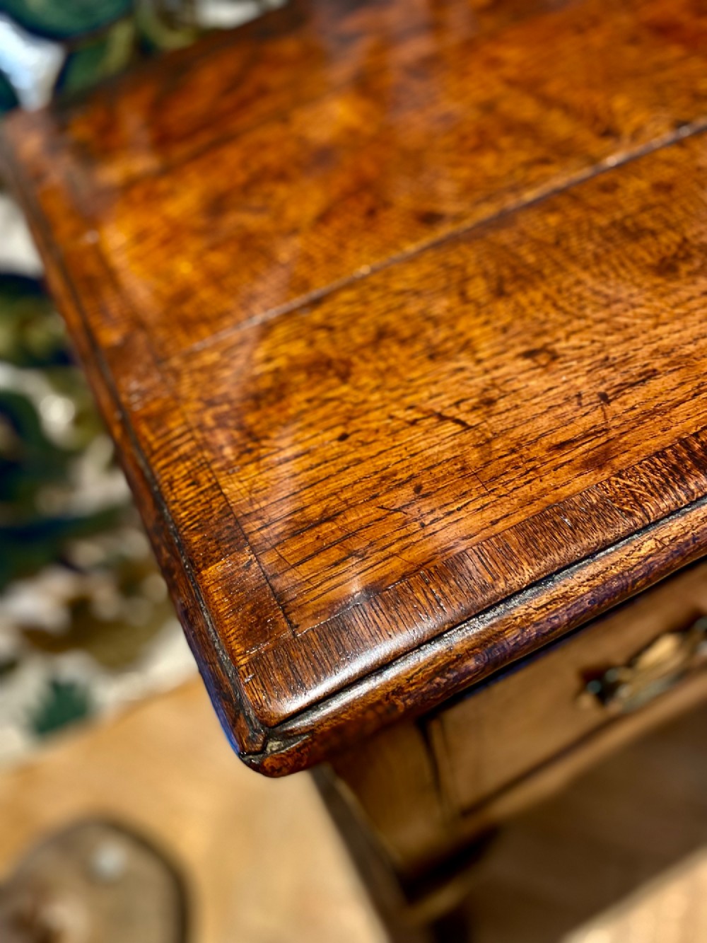 A Georgian oak dresser base featuring three drawers with brass handles, a scalloped apron, and front cabriole legs. View VII