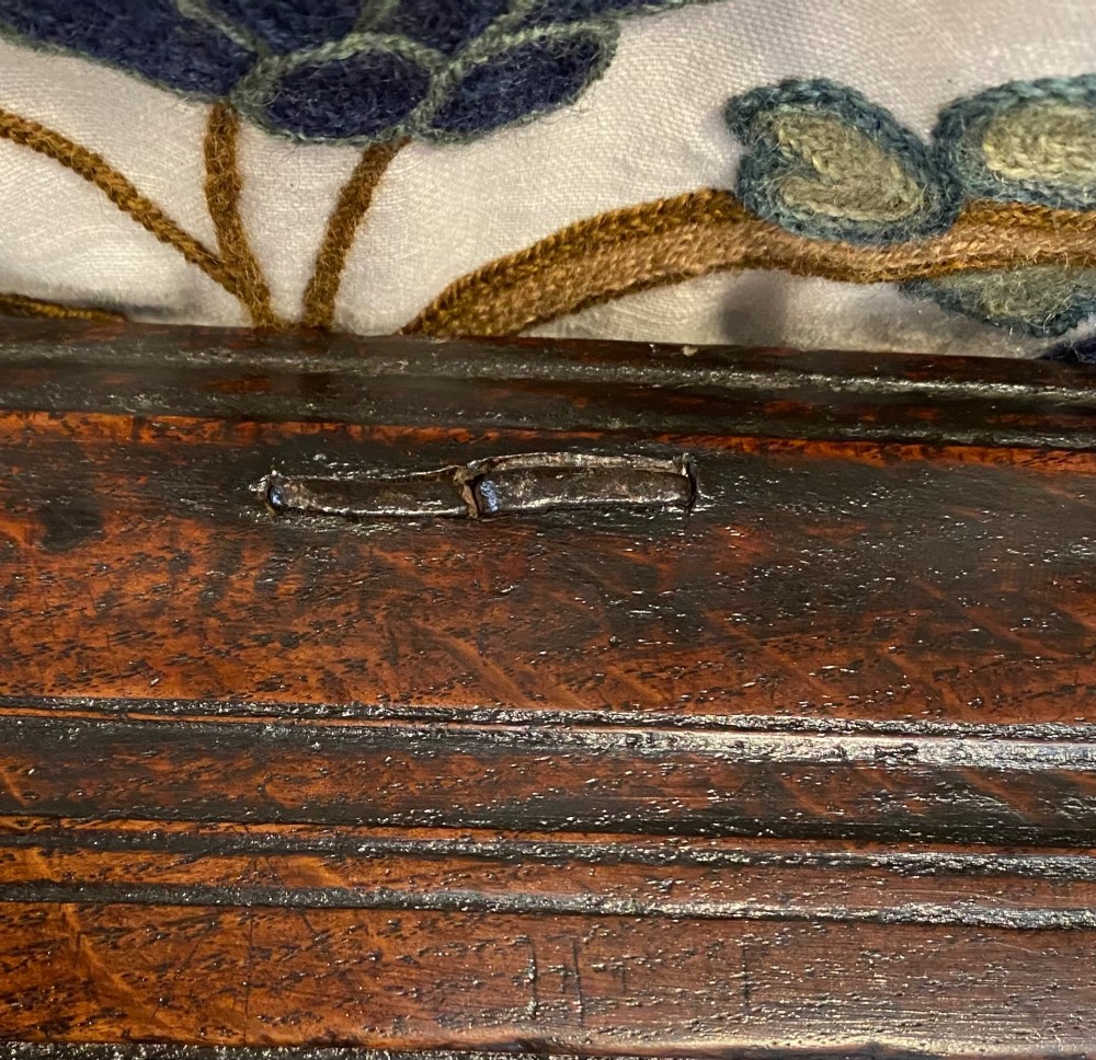 A dark carved oak coffer featuring a three-panel hinged top and three front panels decorated with carved diamond motifs and central rosettes. View VI
