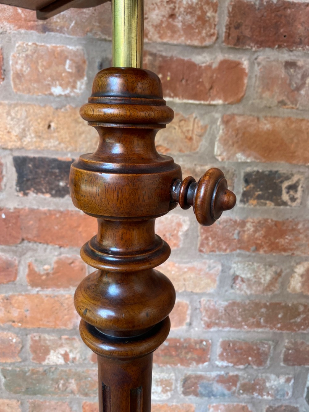 An antique mahogany duet music stand featuring double lyre-shaped rests, an adjustable brass stem, and a turned pedestal base on tripod feet. View IX