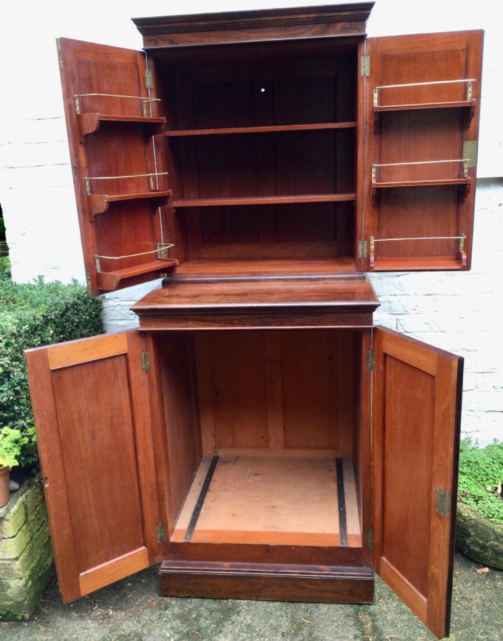 A tall two-tier dark rosewood cabinet with fielded panel doors, a moulded top cornice, and visible wood graining. View IV