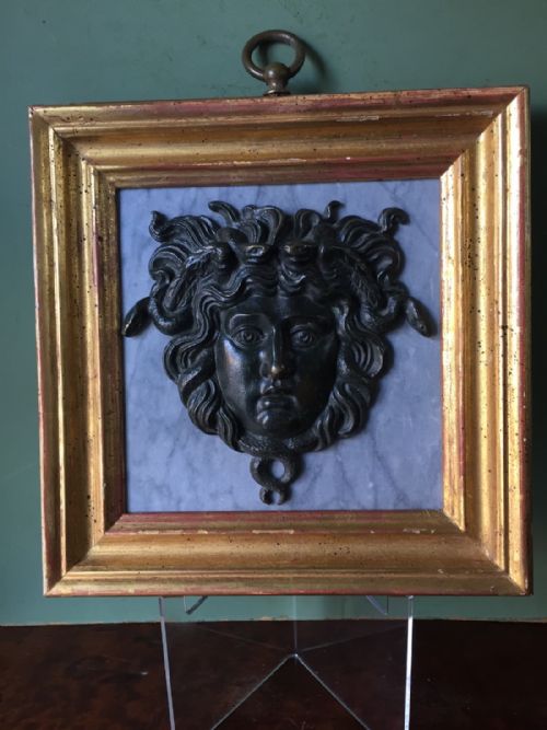 fig 1. C19th 'Grand Tour' souvenir bronze mask of Medusa , mounted upon a pale grey marble panel and set in a gilt-wood frame.