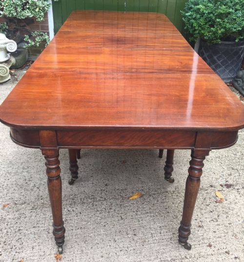 fig 1. A Regency mahogany extending dining table with turned legs and brass castors.