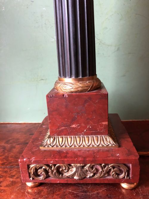 fig 1. Late 19th-century French Empire style table lamp featuring a dark patinated bronze fluted column on a red marble base with gilded ormolu accents.