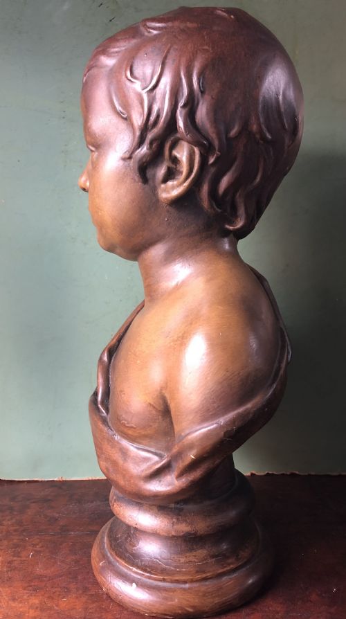fig 1. An early nineteenth-century patinated plaster bust of a young boy with draped shoulder fabric, set on a turned circular pedestal base.