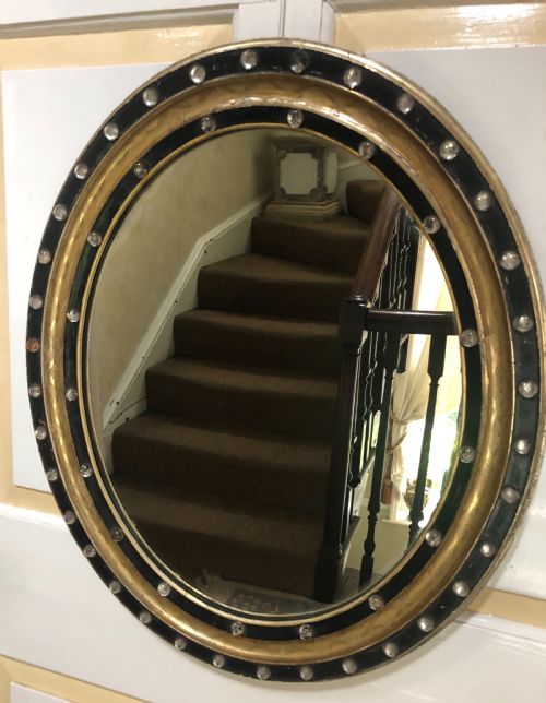 C19th Irish Oval Mirror with Ebonised and Gilded Glass Facet Mounted Frame with Silvered Outer Edge .