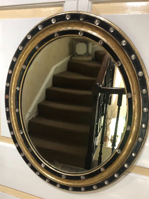 fig 1. C19th Irish oval mirror with ebonised and gilded glass facet mounted frame with silvered outer edge .